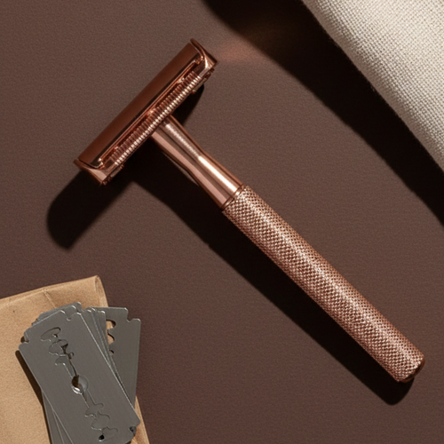 Bronze safety razor with razor heads on a brown surface